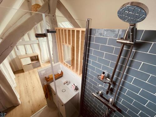 La salle de bains mansardée est pourvue d'une douche et d'un lavabo. dans l'établissement Notre coin secret - Jolie duplex au fil du Robec - 386, à Rouen