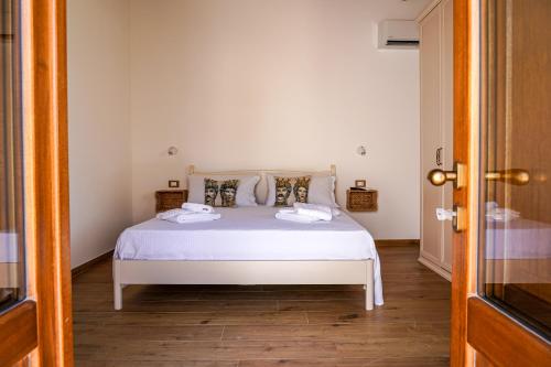 a bedroom with a white bed and a wooden floor at Agriturismo Tenute Mauro in Ispica