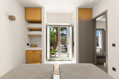 a bedroom with a bed and a door to a patio at Clementina Paros in Naousa