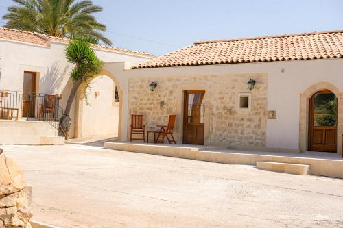 a house with a courtyard and a palm tree at Agriturismo Tenute Mauro in Ispica