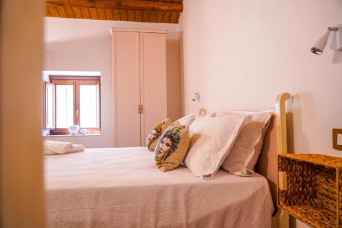 a bedroom with a bed with white sheets and pillows at Agriturismo Tenute Mauro in Ispica
