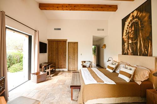 une chambre avec un grand lit et une grande fenêtre dans l'établissement Auberge de l'Oumède, à Saint-Tropez