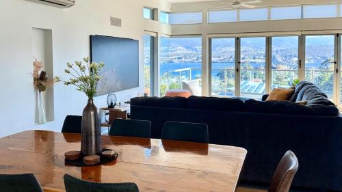 a living room with a blue couch and a table at The MBM - Modern 4BR Home, Spacious, Views, Ideal for Groups in Montagu Bay