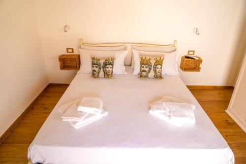 a bedroom with a white bed with two pillows at Agriturismo Tenute Mauro in Ispica