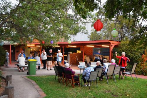 a group of people sitting in chairs in a yard at River Country Inn in Moama