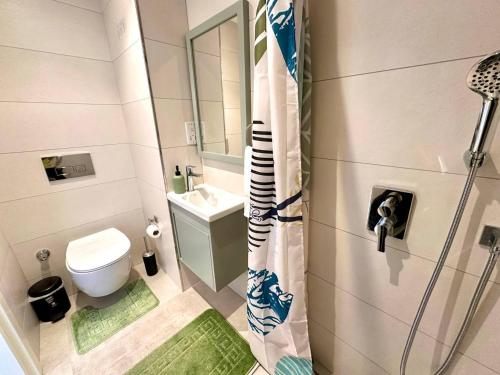 a bathroom with a shower with a toilet and a sink at The Olive Beachfront Apartment & Spa in Bahçeli
