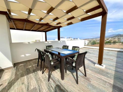 a dining room with a table and chairs at The Olive Beachfront Apartment & Spa in Bahçeli
