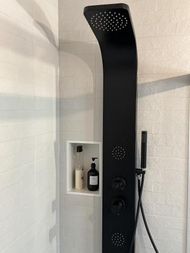 a shower with a black shower head in a bathroom at Apartamentos La Gruta de Aracena 3 in Aracena