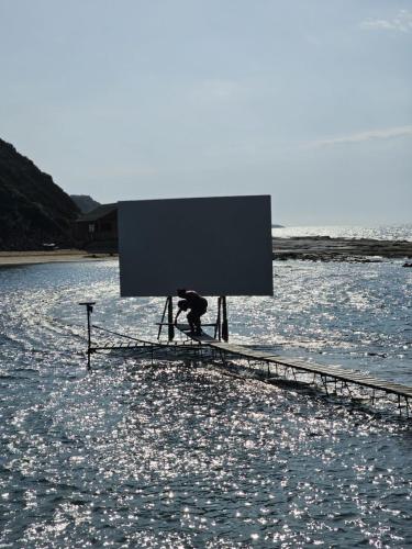 a person sitting on a stand in the water at The Olive Beachfront Apartment & Spa in Bahçeli
