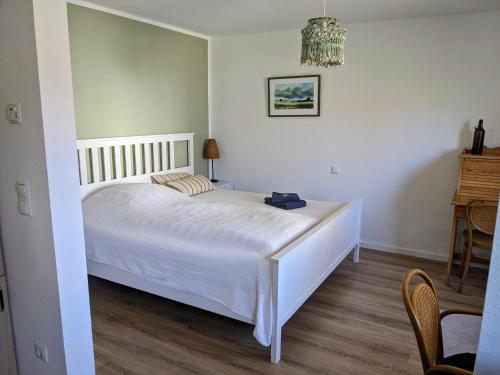 a bedroom with a white bed and a table at Klein&Fein-Stadtnahes Apartment in Celle