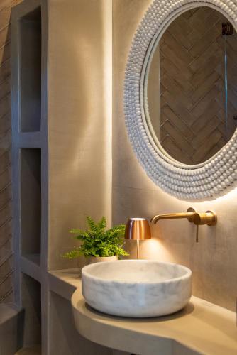 a bathroom with a sink and a mirror at Soborgo Exquisite Villas in Tinos Town