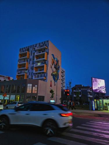 a white car driving down a street in front of a building at Tirana Magnifique Apartments in Tirane