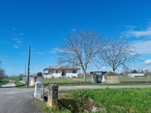 a road in front of a house with a fence at In campagna vicino al mare in Rivignano