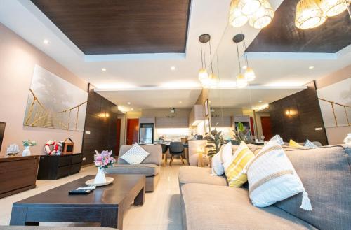 a living room with a couch and a coffee table at Phirom2 pool villa pattaya in Jomtien Beach