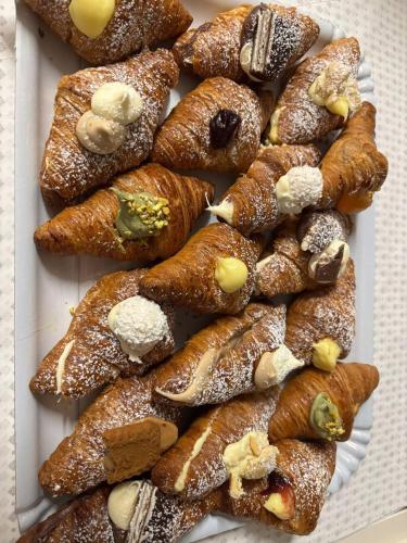 a white plate of pastries covered in powdered sugar at Porta Piccola Residence in Castellaneta