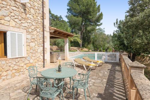 a patio with a table and chairs and a fence at Hall of The Mountain Pool - Bunyola in Bunyola