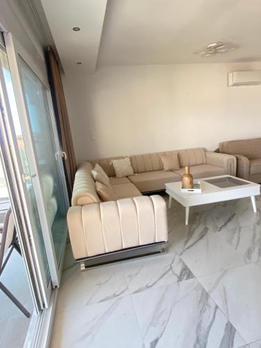 a living room with a couch and a table at Alina's & Alex's Apartments in Néa Péramos