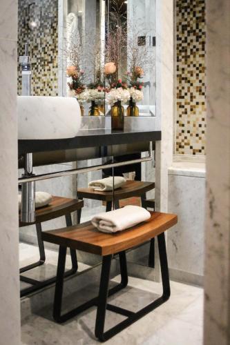a bathroom with a sink and two tables with towels at Hotel Montalembert in Paris