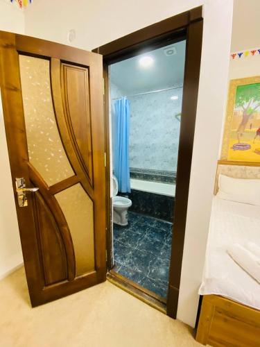 a bathroom with a door leading to a toilet at Afsona guest house in Bukhara