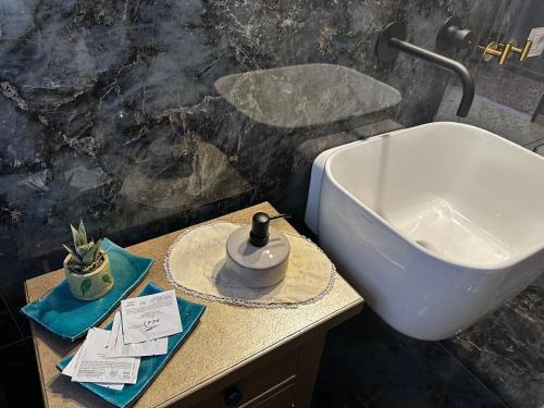 a bathroom with a sink and a toilet and a counter at Locanda 3848 in Pitigliano