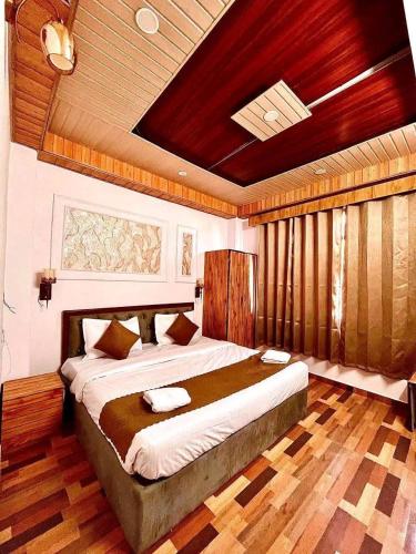 a bedroom with a large bed with a wooden ceiling at The Precesion Palace Hotel Near IGI Airport in New Delhi