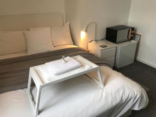 a hotel room with a bed and a tv at fAiRy DeLL Guesthouse, with cozy lockable rooms, tv, tea tray with choccies, free wifi and parking, 24hr check in, COA, all are welcome in Bradford