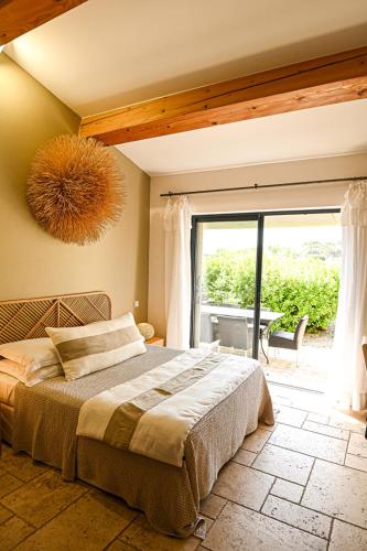 a bedroom with a large bed and a large window at Auberge de l'Oumède in Saint-Tropez