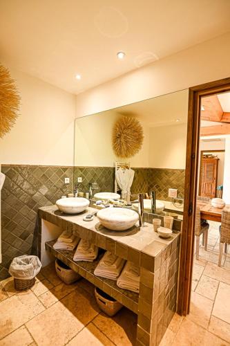 une salle de bain avec deux lavabos et un grand miroir dans l'établissement Auberge de l'Oumède, à Saint-Tropez
