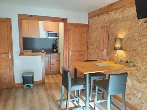 une cuisine et une salle à manger avec une table et des chaises dans l'établissement Les Chalets d'Arlos, à Arlos