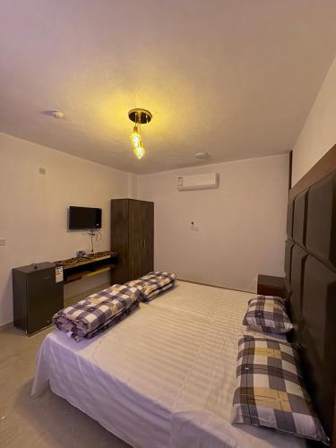 a bedroom with a large bed with pillows on it at Camel Dive Club By The Sea Inn in Jurf ad Darāwīsh