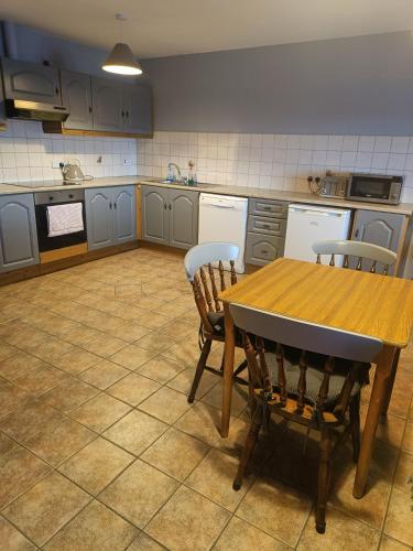 a kitchen with a wooden table and two chairs at Dingle Town Center Apartment in Dingle
