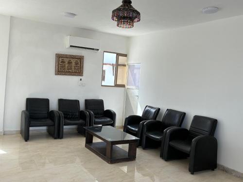 a waiting room with black chairs and a table at Camel Dive Club By The Sea Inn in Jurf ad Darāwīsh
