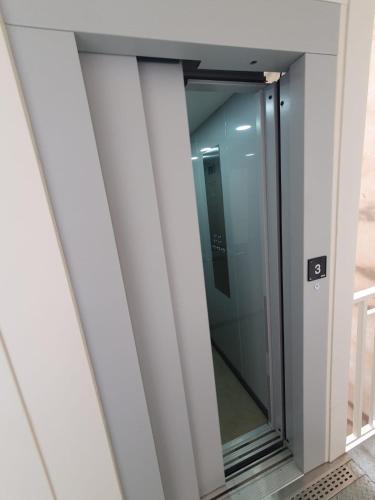 a glass elevator in a building with a mirror at Appartamenti La Fenice in Trapani