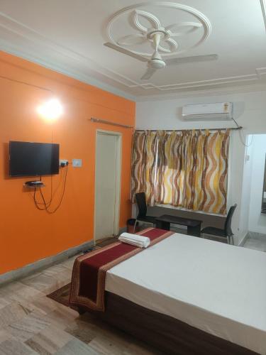 a bedroom with a bed and a flat screen tv at Hotel Aditya Palace in Rānchī
