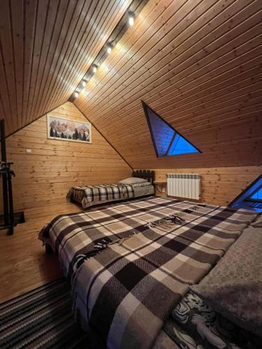 a bedroom with a large bed in a wooden ceiling at "Файна хата" in Synevyrsʼka Polyana