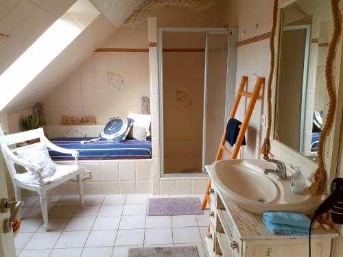 a bathroom with a sink and a bed in a attic at Luett Huus in Eckernförde