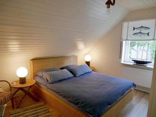 a bedroom with a bed with two pillows and a window at Luett Huus in Eckernförde