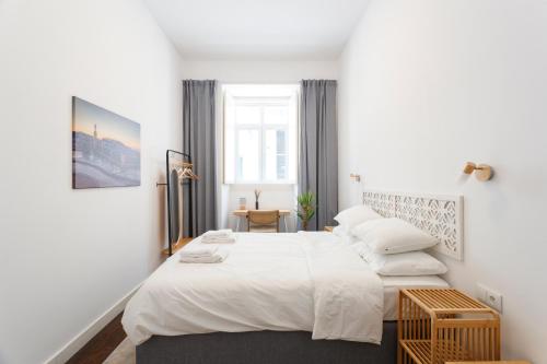 a bedroom with a large bed with white sheets and pillows at StayBA Guesthouse in Lisbon