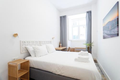 a bedroom with a large white bed and a window at StayBA Guesthouse in Lisbon