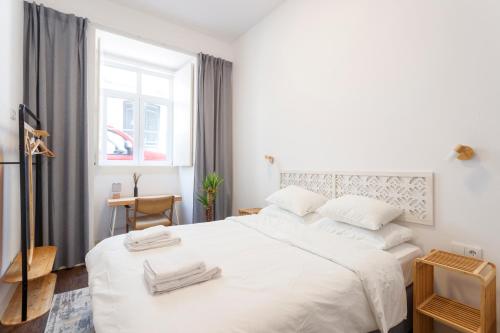 a bedroom with a white bed with two towels on it at StayBA Guesthouse in Lisbon