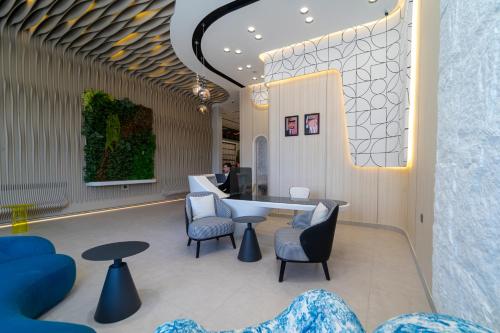 a lobby with blue chairs and a table and chairs at Hill Top Hotel in Aqaba
