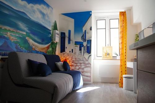 - un salon avec un canapé et une fresque murale dans l'établissement Studio cosy au style méditérannéen, à Clermont-Ferrand