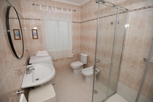 a bathroom with a toilet and a sink and a shower at Casa Cancela Combarro in Pontevedra