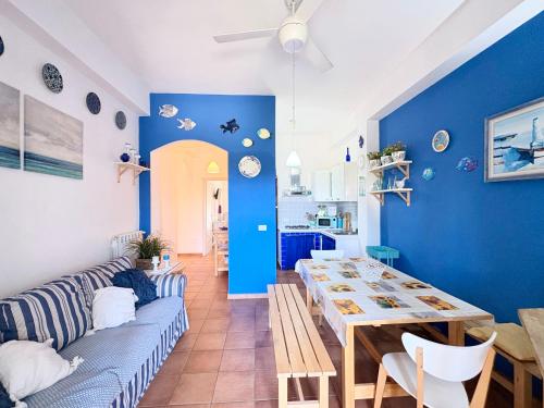 a living room with a table and a blue wall at Appartamento Marina in Tropea
