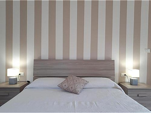 a bedroom with a large bed with two lamps on it at Residenza Villa Gorìa in Pontestura