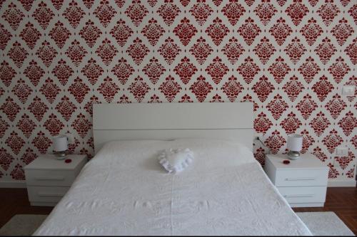 a bedroom with a white bed with two night stands at Residenza Villa Gorìa in Pontestura