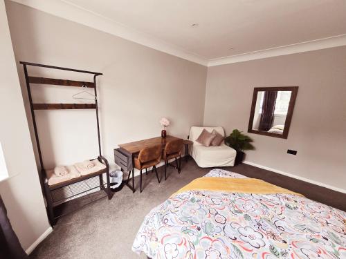 a bedroom with a bed and a desk and a chair at Alross Guest House in London