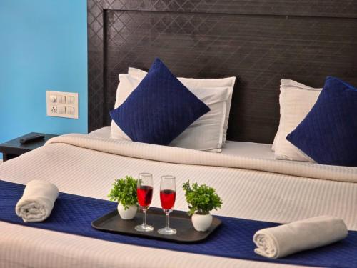 two glasses of wine on a tray on a bed at Hotel City Gold - Hotel in Dharamshala in Dharmsala