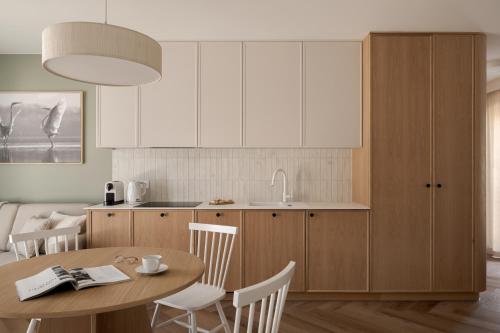 a kitchen with a wooden table and a kitchen with white cabinets at Piwna Apartamenty nad morzem Władysławowo in Władysławowo