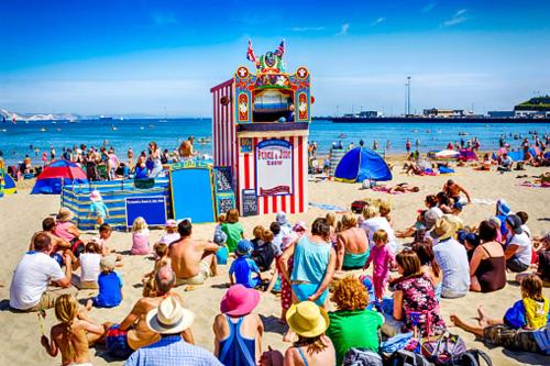 a crowd of people sitting on a beach at The Beach House in Melcombe Regis